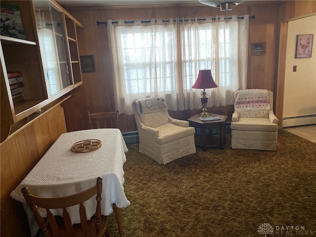 living area featuring wood walls, carpet, and a baseboard heating unit