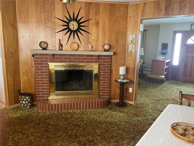 living room with carpet, a brick fireplace, and wood walls