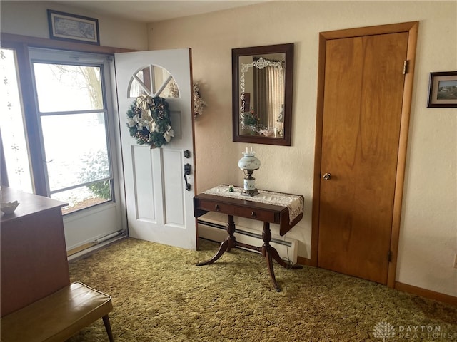 doorway featuring carpet flooring, a healthy amount of sunlight, and a baseboard heating unit