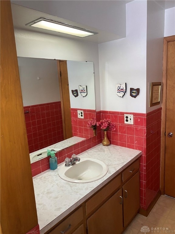 bathroom with tile patterned floors, vanity, and tile walls