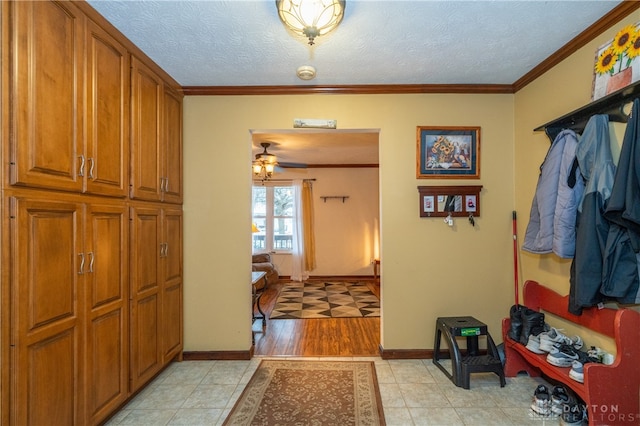 mudroom with ceiling fan, ornamental molding, and a textured ceiling