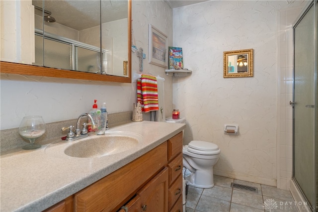 bathroom with toilet, tile patterned flooring, vanity, and walk in shower