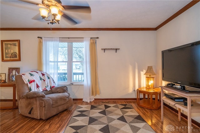 living room featuring hardwood / wood-style flooring, ceiling fan, and crown molding