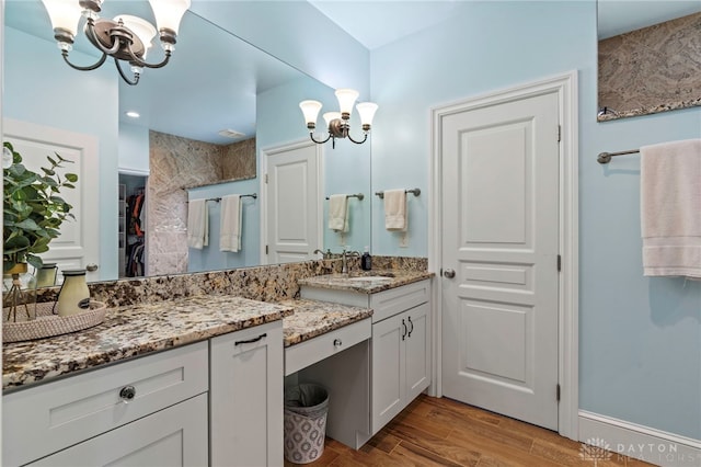 bathroom featuring hardwood / wood-style flooring, vanity, and a notable chandelier