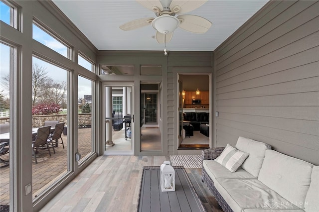 unfurnished sunroom featuring ceiling fan