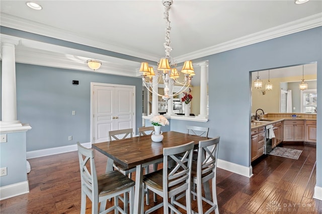 dining area with dark hardwood / wood-style flooring, ornate columns, sink, and a chandelier