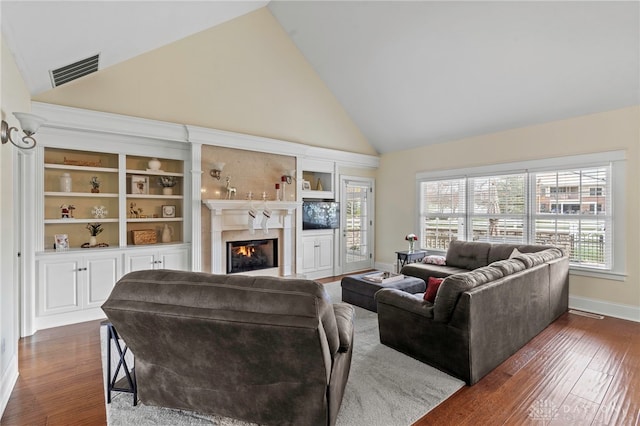 living room with a high end fireplace, dark hardwood / wood-style floors, and high vaulted ceiling