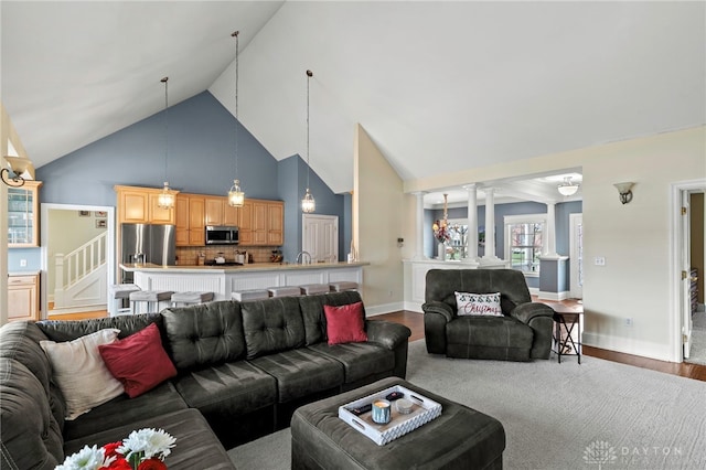 living room featuring wood-type flooring and high vaulted ceiling