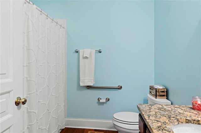 bathroom with toilet, vanity, and hardwood / wood-style flooring