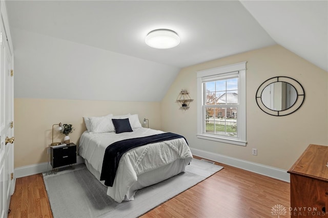 bedroom featuring wood-type flooring and vaulted ceiling