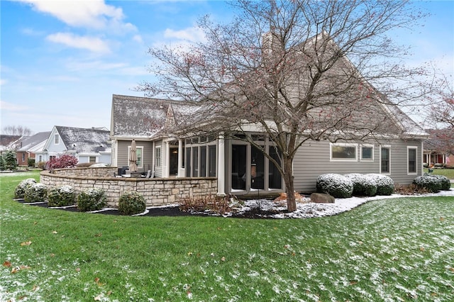 back of house with a lawn and a sunroom