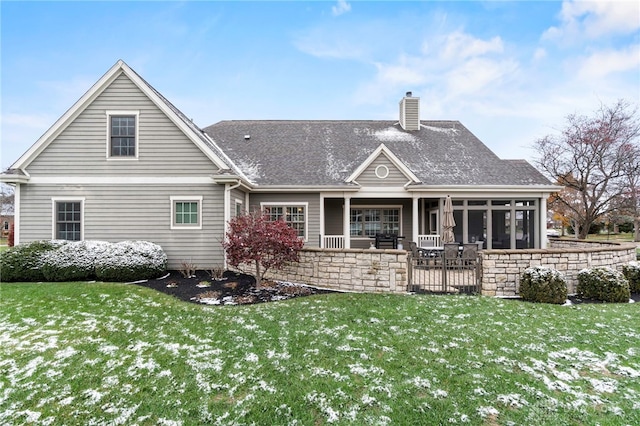 rear view of house featuring a yard and a sunroom