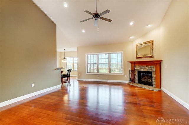 unfurnished living room featuring ceiling fan, wood-type flooring, a fireplace, and high vaulted ceiling