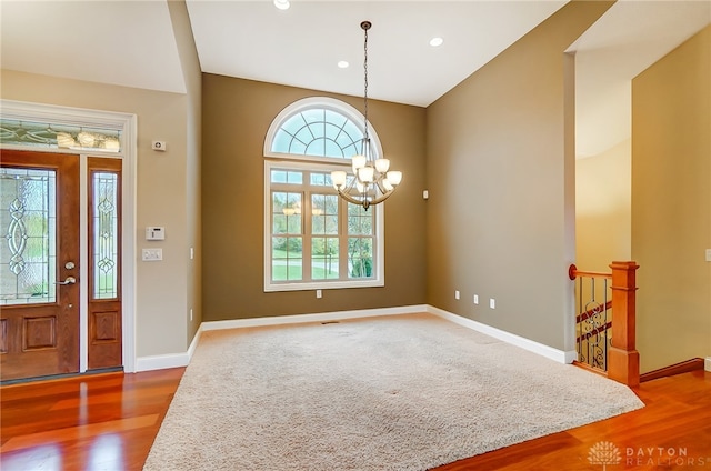 foyer entrance with hardwood / wood-style floors and an inviting chandelier