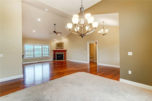 unfurnished living room with dark hardwood / wood-style flooring, high vaulted ceiling, and ceiling fan with notable chandelier