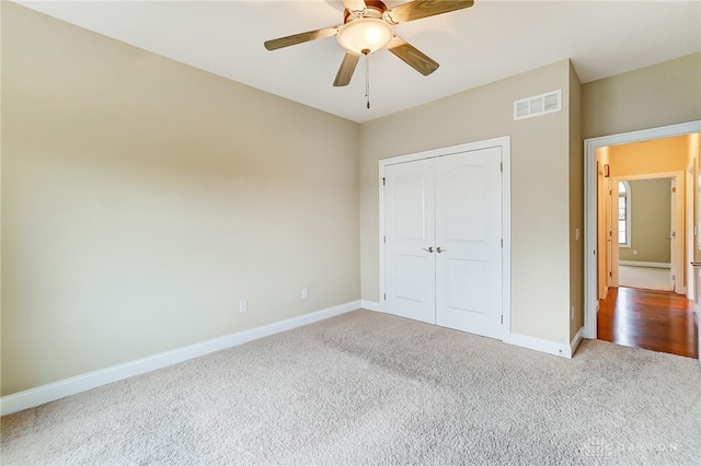 unfurnished bedroom with ceiling fan, a closet, and light colored carpet