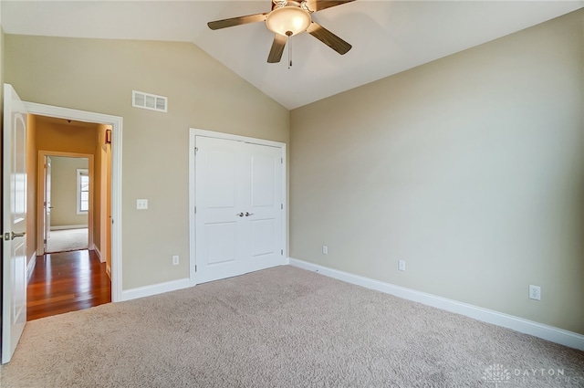 unfurnished bedroom with carpet, ceiling fan, lofted ceiling, and a closet