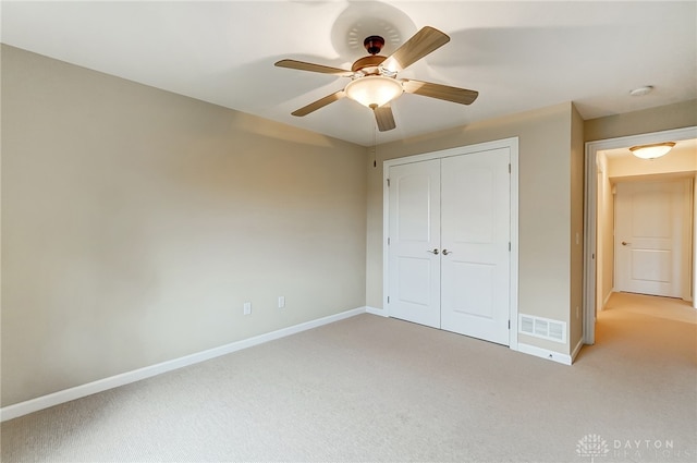 unfurnished bedroom featuring a closet, ceiling fan, and light colored carpet