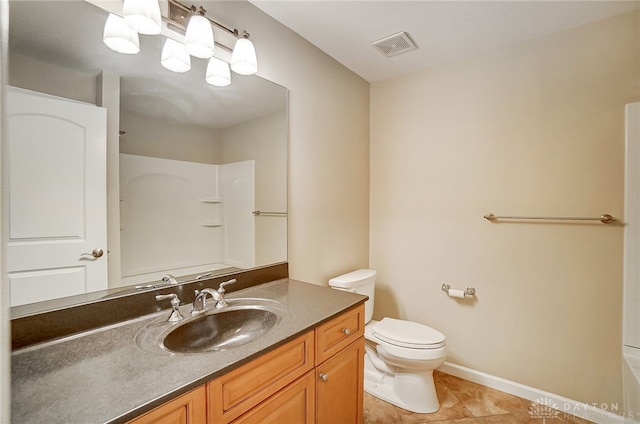 bathroom with tile patterned floors, vanity, toilet, and walk in shower