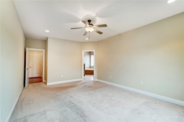 unfurnished bedroom with ceiling fan, light carpet, and connected bathroom