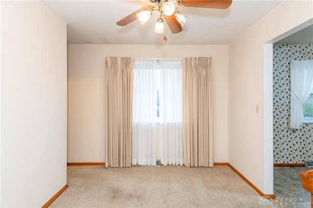 carpeted empty room featuring plenty of natural light and ceiling fan