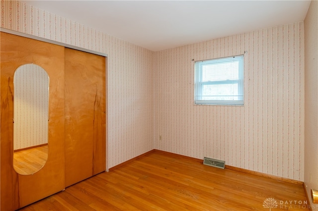 unfurnished bedroom featuring hardwood / wood-style flooring and a closet