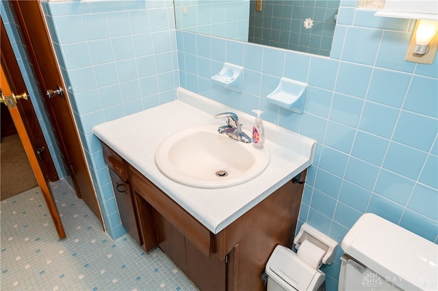 bathroom featuring backsplash, tile patterned floors, vanity, tile walls, and toilet