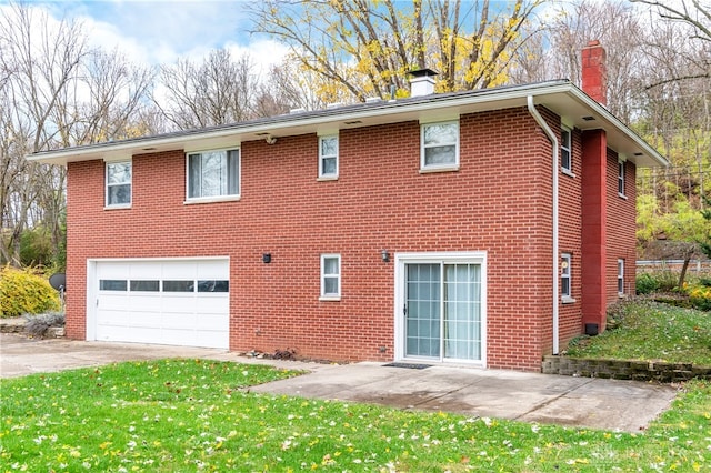 back of property with a garage and a yard