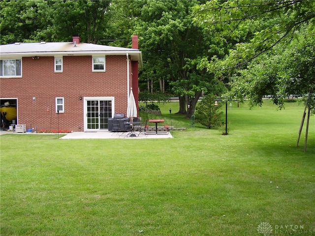 back of house with a patio area and a yard