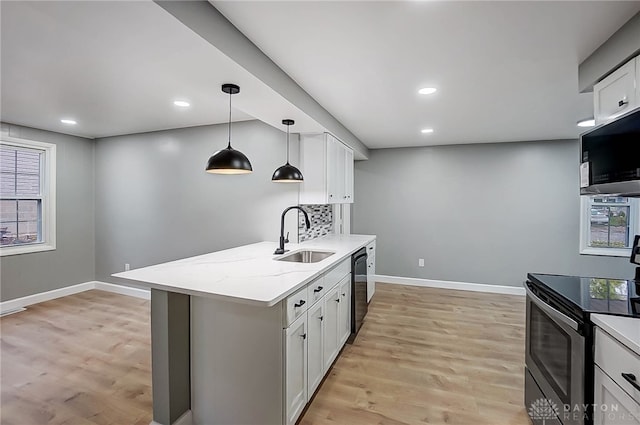 kitchen with white cabinets, hanging light fixtures, sink, a wealth of natural light, and appliances with stainless steel finishes