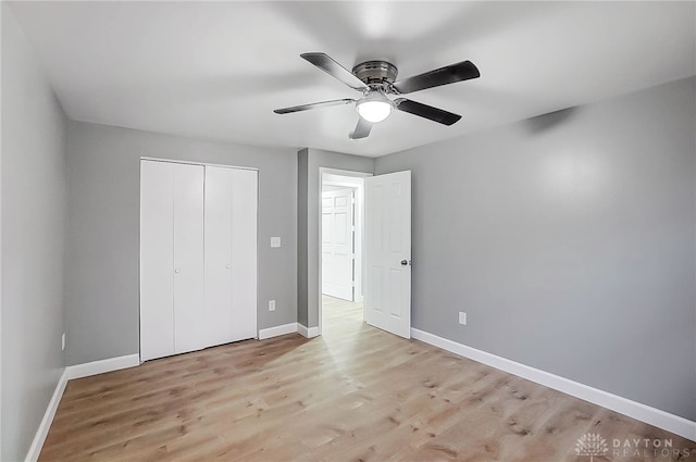 unfurnished bedroom with a closet, light hardwood / wood-style flooring, and ceiling fan