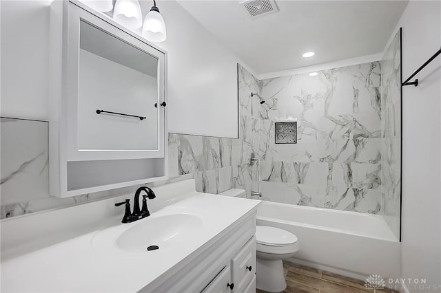 full bathroom featuring toilet, vanity, tiled shower / bath combo, and hardwood / wood-style flooring