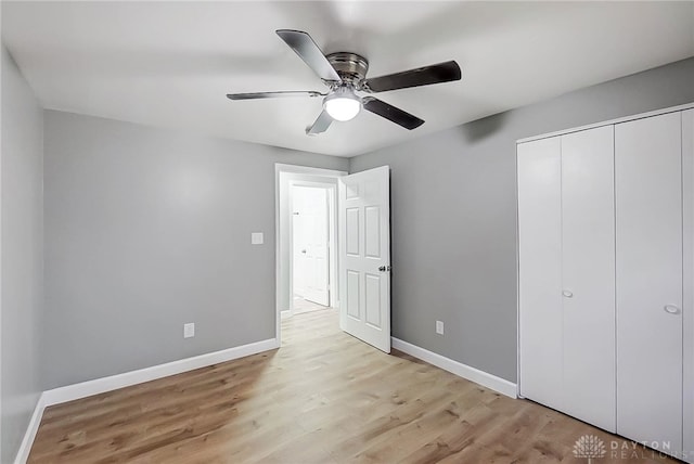 unfurnished bedroom featuring ceiling fan, light hardwood / wood-style floors, and a closet