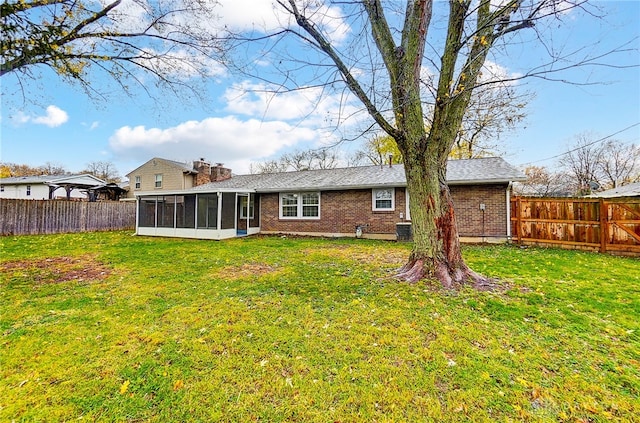 rear view of property featuring a lawn and a sunroom