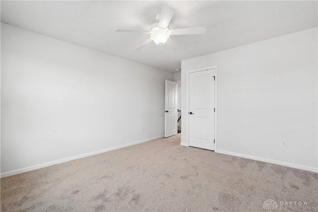 carpeted spare room featuring ceiling fan