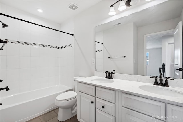 full bathroom featuring tile patterned flooring, vanity, toilet, and tiled shower / bath combo