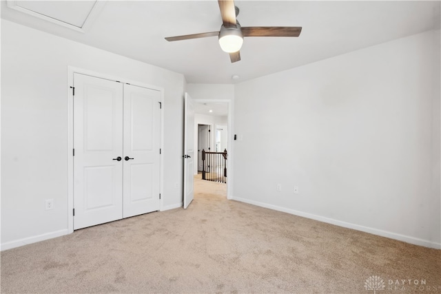 unfurnished bedroom with ceiling fan, a closet, and light colored carpet