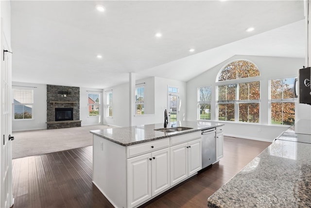 kitchen featuring white cabinets, light stone countertops, stainless steel appliances, and a kitchen island with sink