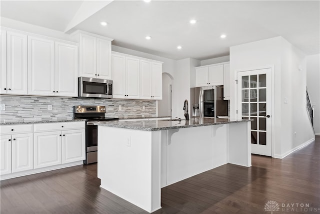 kitchen featuring white cabinetry, a kitchen island with sink, dark hardwood / wood-style flooring, and stainless steel appliances