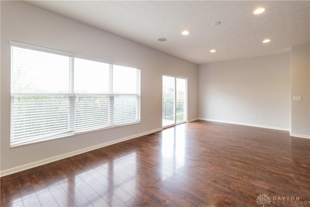 unfurnished room with dark hardwood / wood-style floors and a healthy amount of sunlight