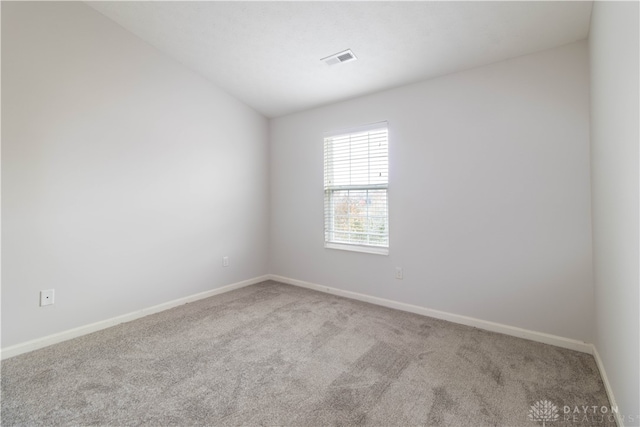 spare room featuring light carpet