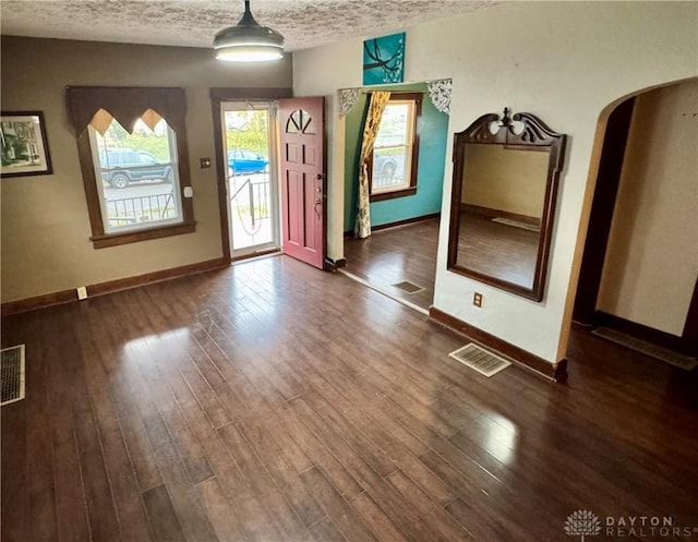 foyer featuring dark hardwood / wood-style flooring and a textured ceiling