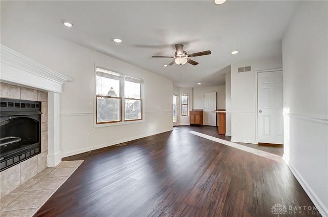 unfurnished living room with a fireplace, wood-type flooring, and ceiling fan