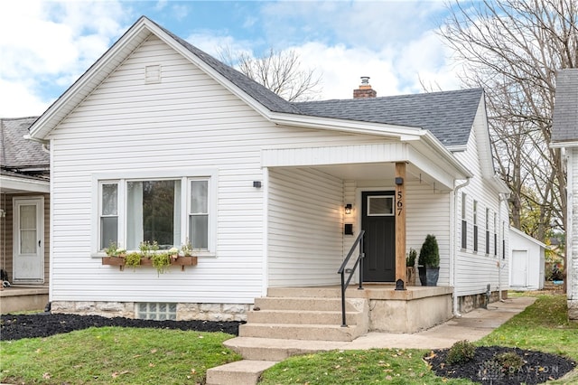 bungalow-style house featuring a front yard, an outbuilding, and a garage