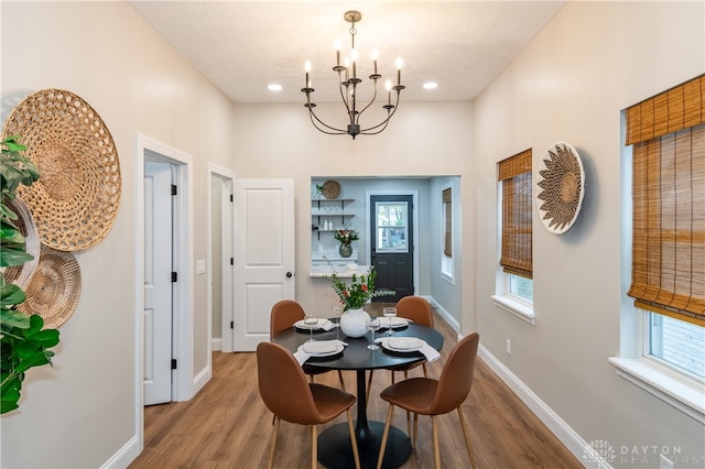 dining space with hardwood / wood-style flooring and a notable chandelier