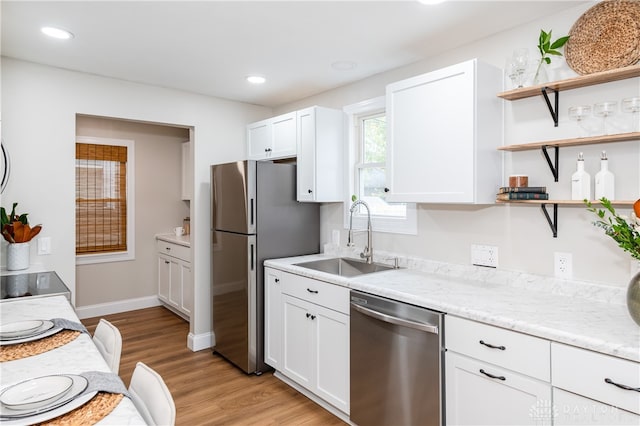 kitchen featuring sink, white cabinets, light hardwood / wood-style flooring, and appliances with stainless steel finishes