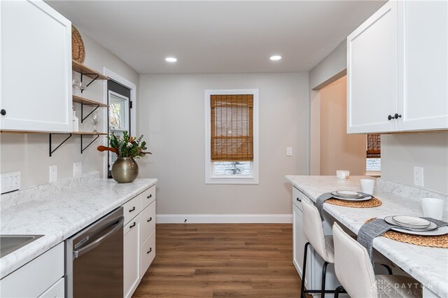 kitchen featuring stainless steel dishwasher, light stone countertops, white cabinetry, and dark wood-type flooring