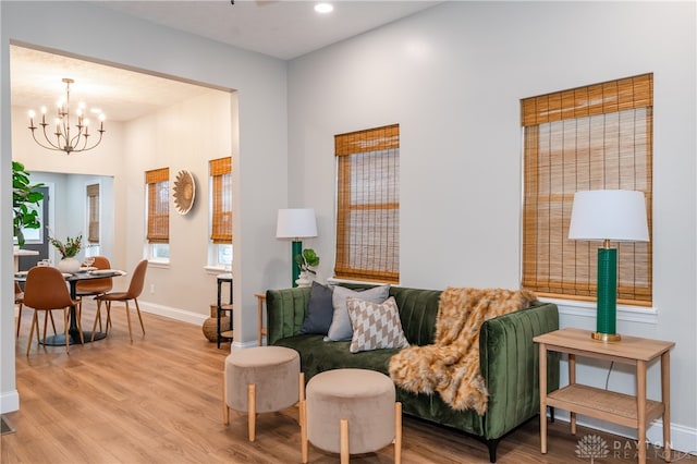 living room featuring light hardwood / wood-style flooring and an inviting chandelier