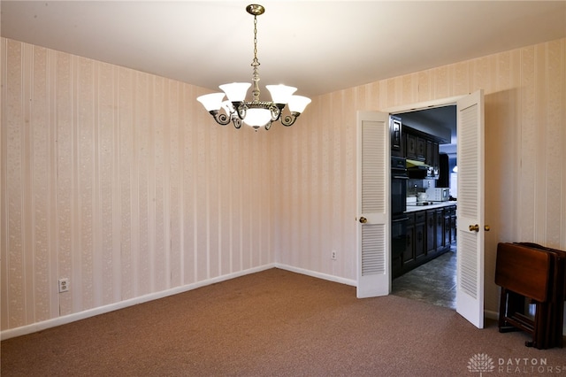 carpeted empty room featuring a notable chandelier