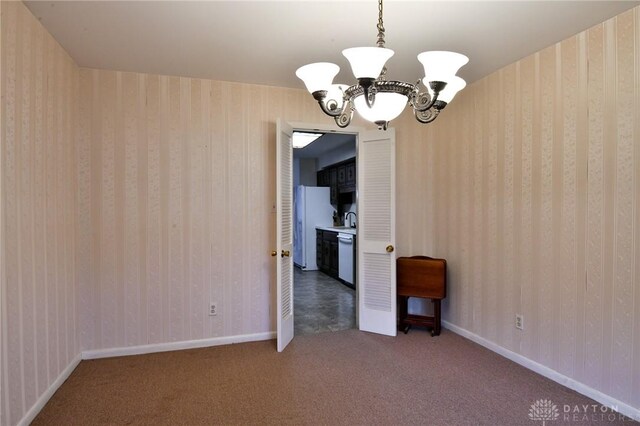 carpeted empty room with an inviting chandelier and sink